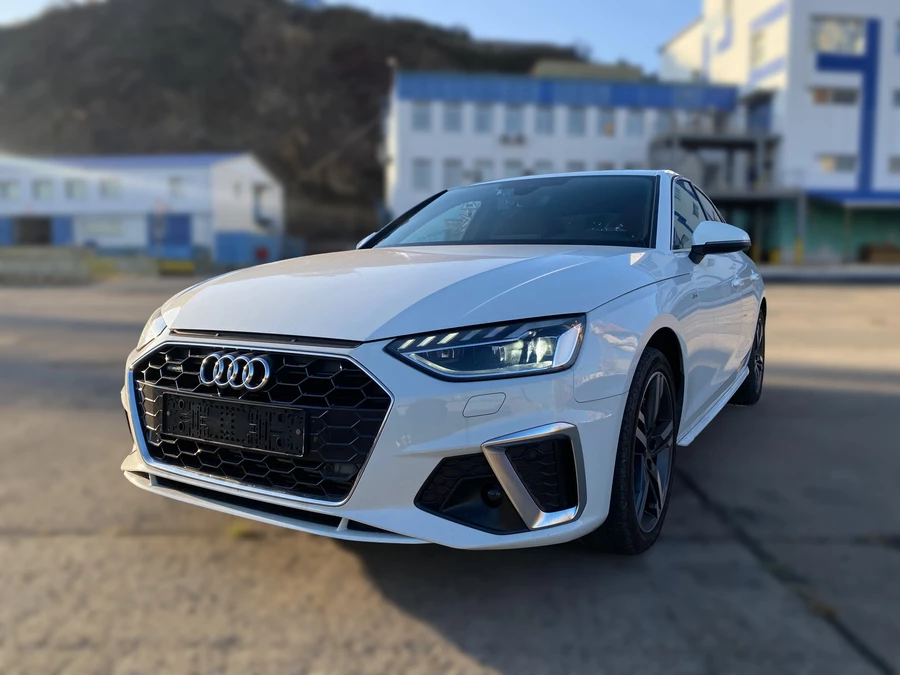 Audi A4 B9 белого цвета на фоне скалы