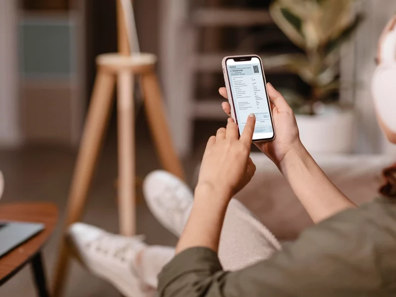 человек смотрит эптс в телефоне сидя на диване