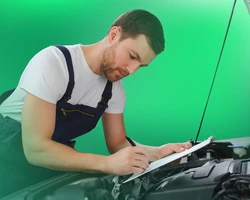 молодой парень проводит техосмотр автомобиля