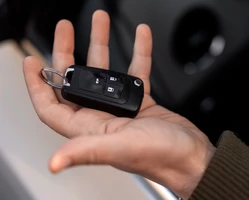 мужская рука держит брелок от автоключей