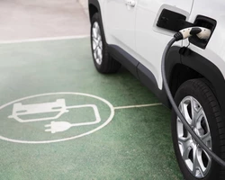 электроавтомобиль белого цветана заправке