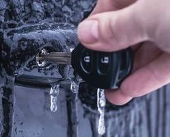 Рука с автомобильным ключом во льду