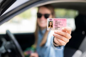 Девушка держит права в руке