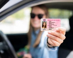 Девушка держит права в руке