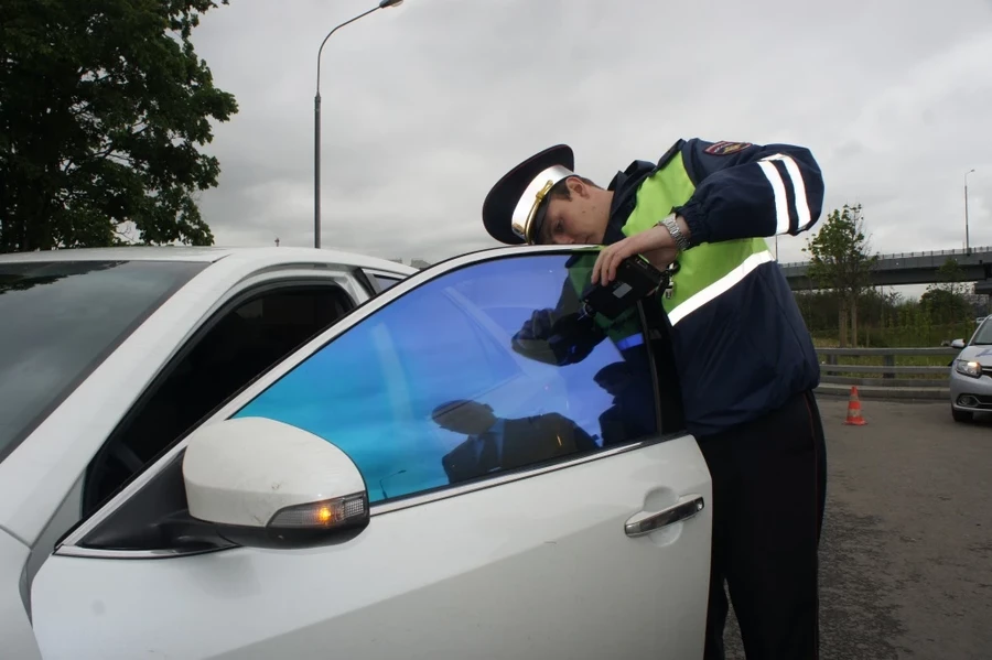 гаишник проверяет тонировку авто