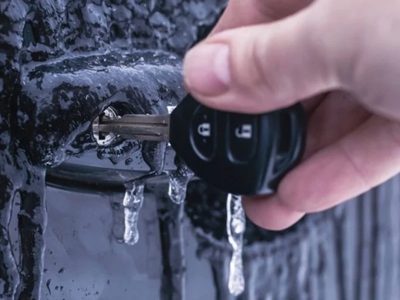 Рука с автомобильным ключом во льду