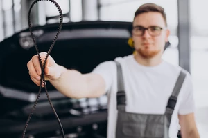 мужчина держит ремень грм