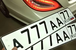 мужчина держит в руках госномер 777