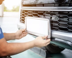 Мужчина снимает номер с автомобиля