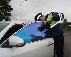 гаишник проверяет тонировку авто