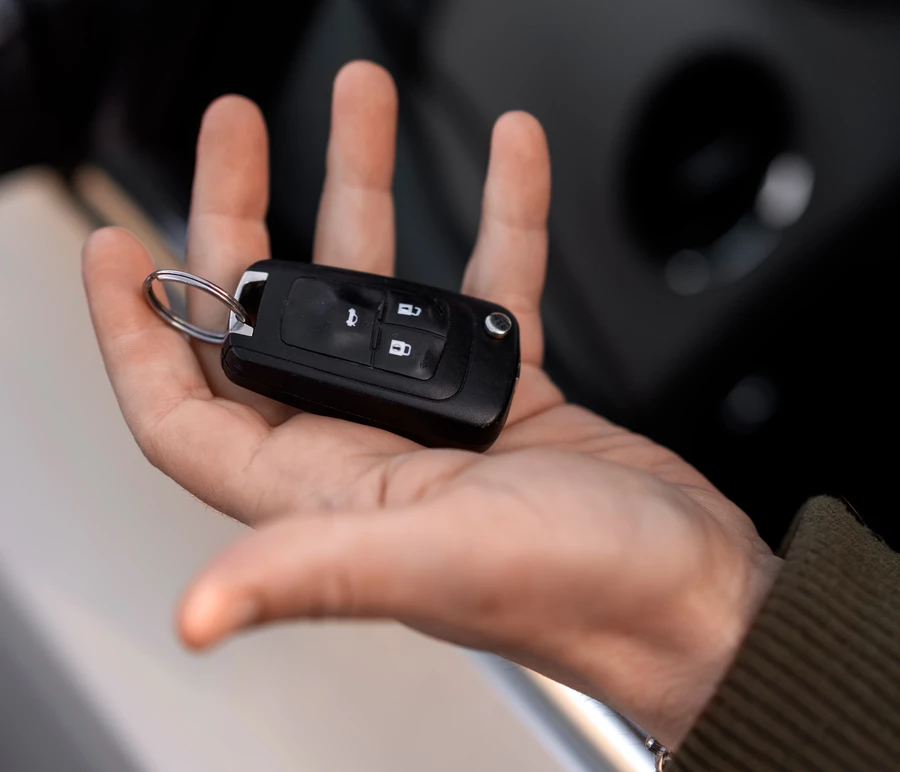 мужская рука держит брелок от автоключей