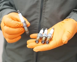 мужские руки держат свечи зажигания