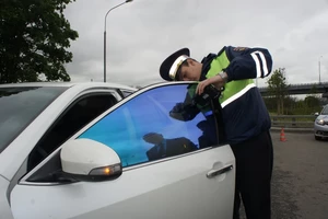 гаишник проверяет тонировку авто