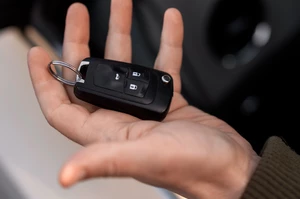 мужская рука держит брелок от автоключей