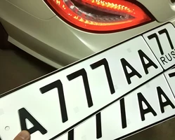 мужчина держит в руках госномер 777