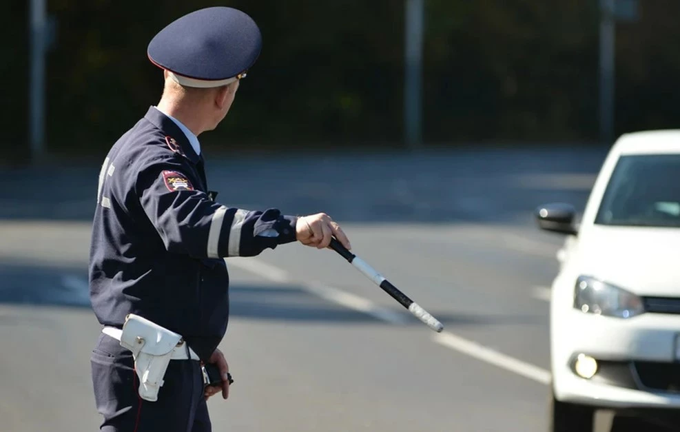 Сотрудник ГАИ с жезлом останавливает машину