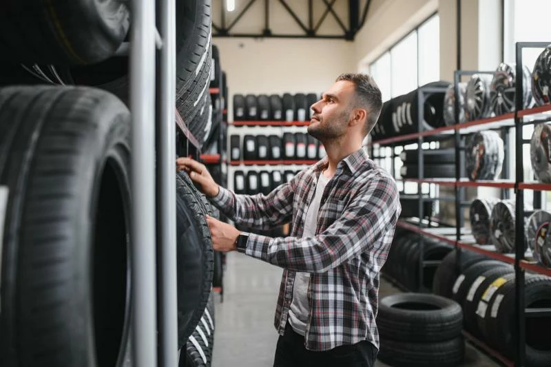 человек выбирает шины в магазине автошин