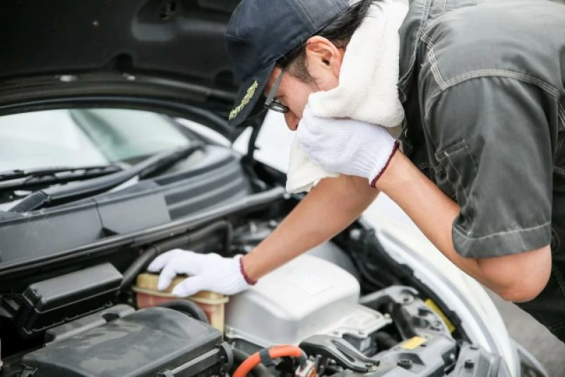 мужчина меняет в машине антифриз