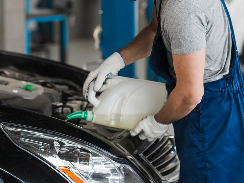 Мужчина заливает масло в автомобиль