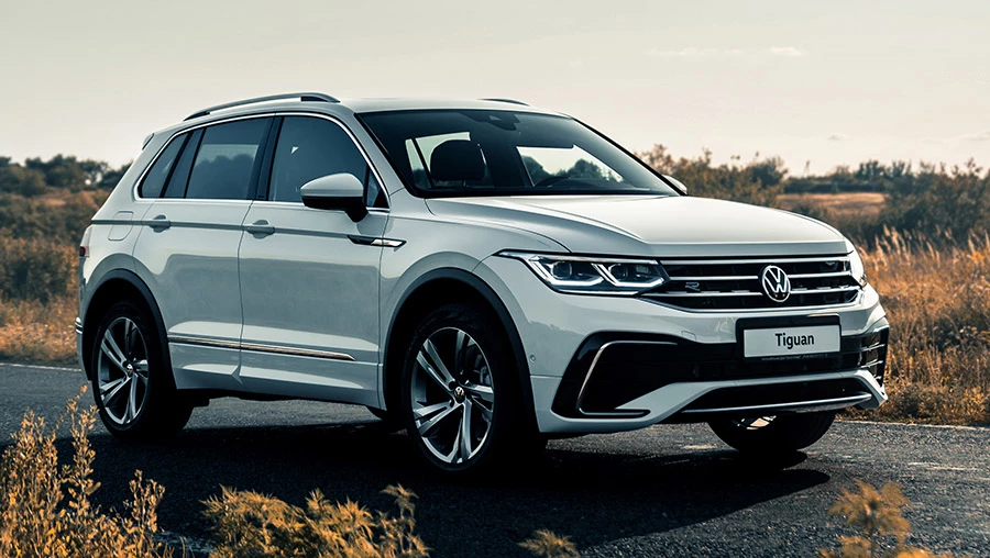 Volkswagen Tiguan белого цвета стоит на асфальтированной дороге загородом